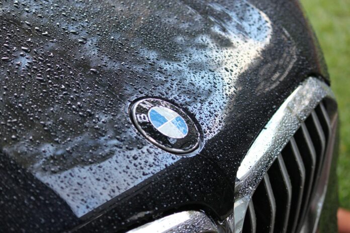 close up of a wet luxury car hood with logo